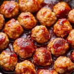 Cranberry glazed turkey meatballs served on a plate with sauce drizzle