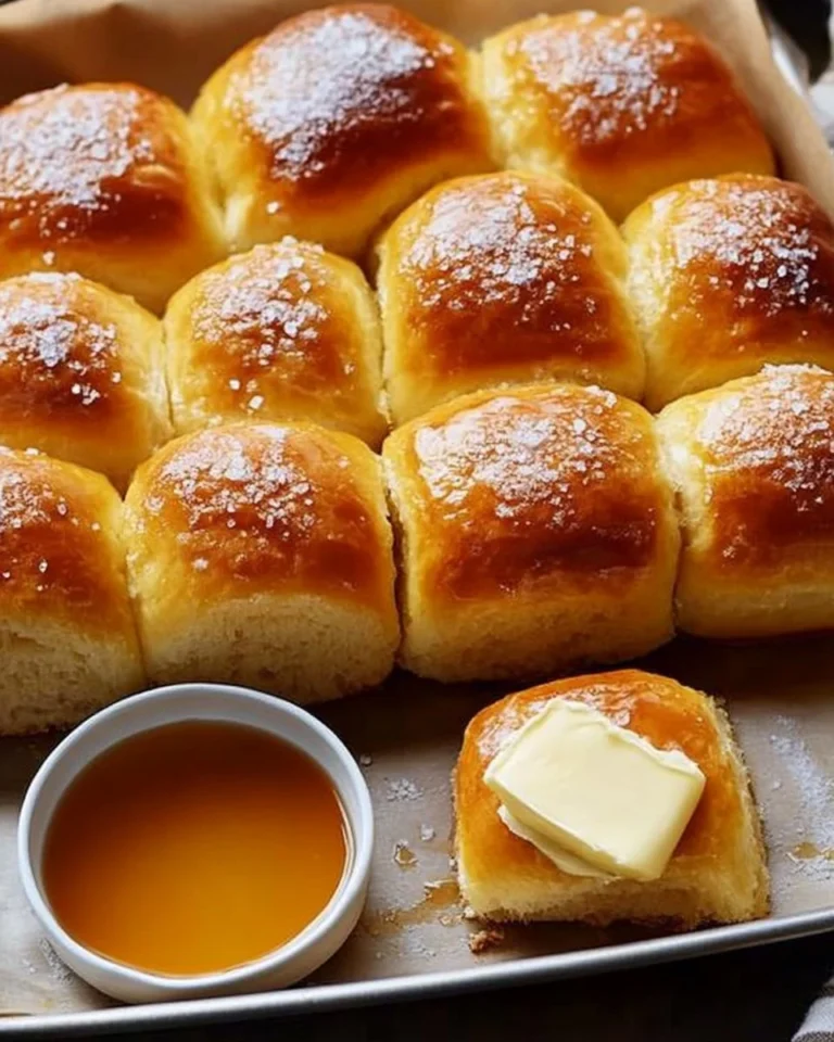Freshly baked sweet potato dinner rolls on a wooden table